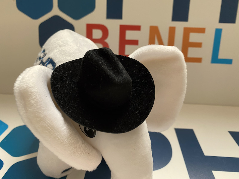 White PHP mascotte with hat and logo of PHPBenelux